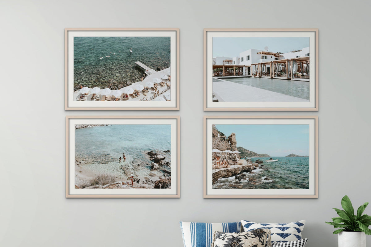 Four framed travel photographs grouped above a neutral sofa