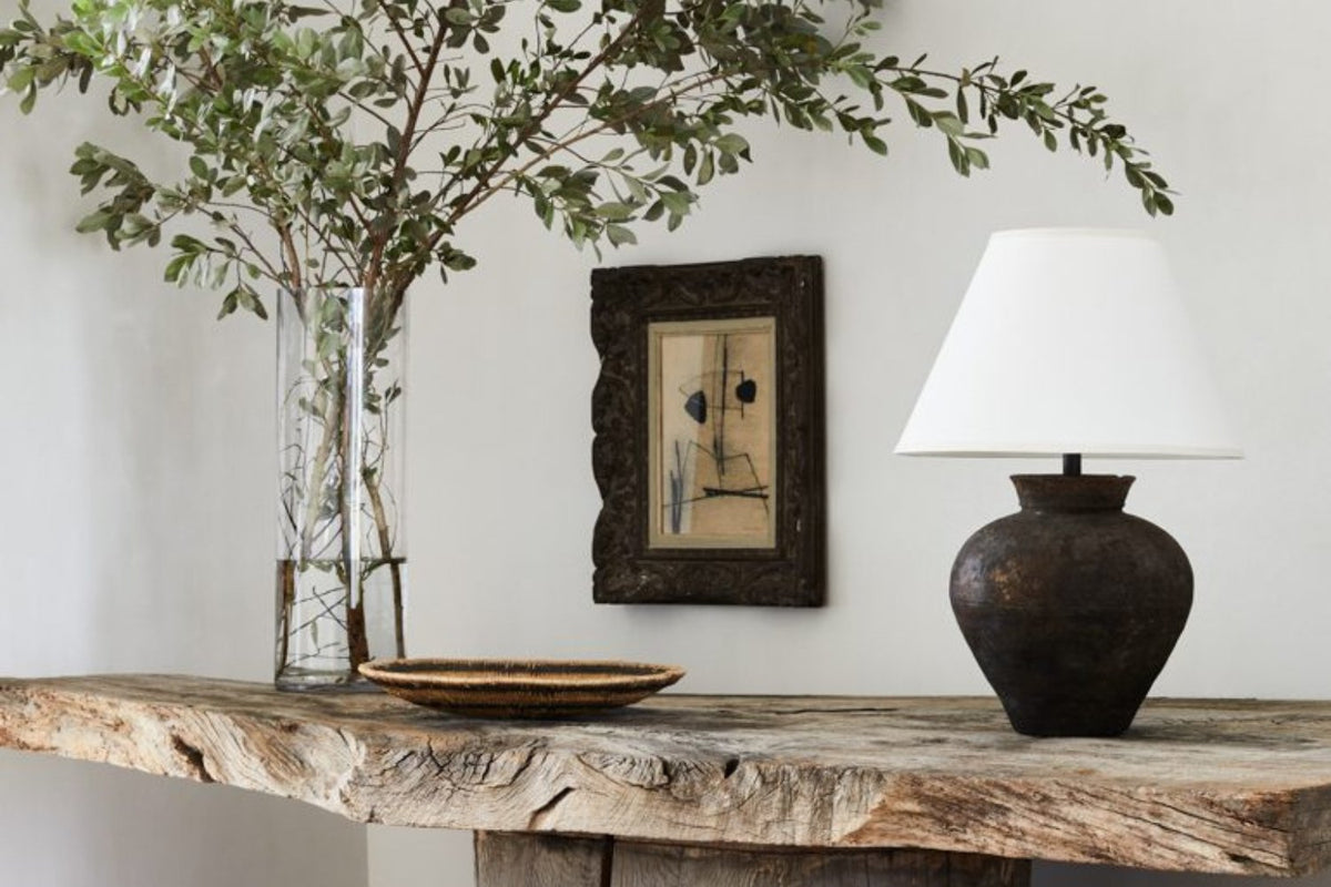 Branch arrangement and framed artwork on a rustic timber console