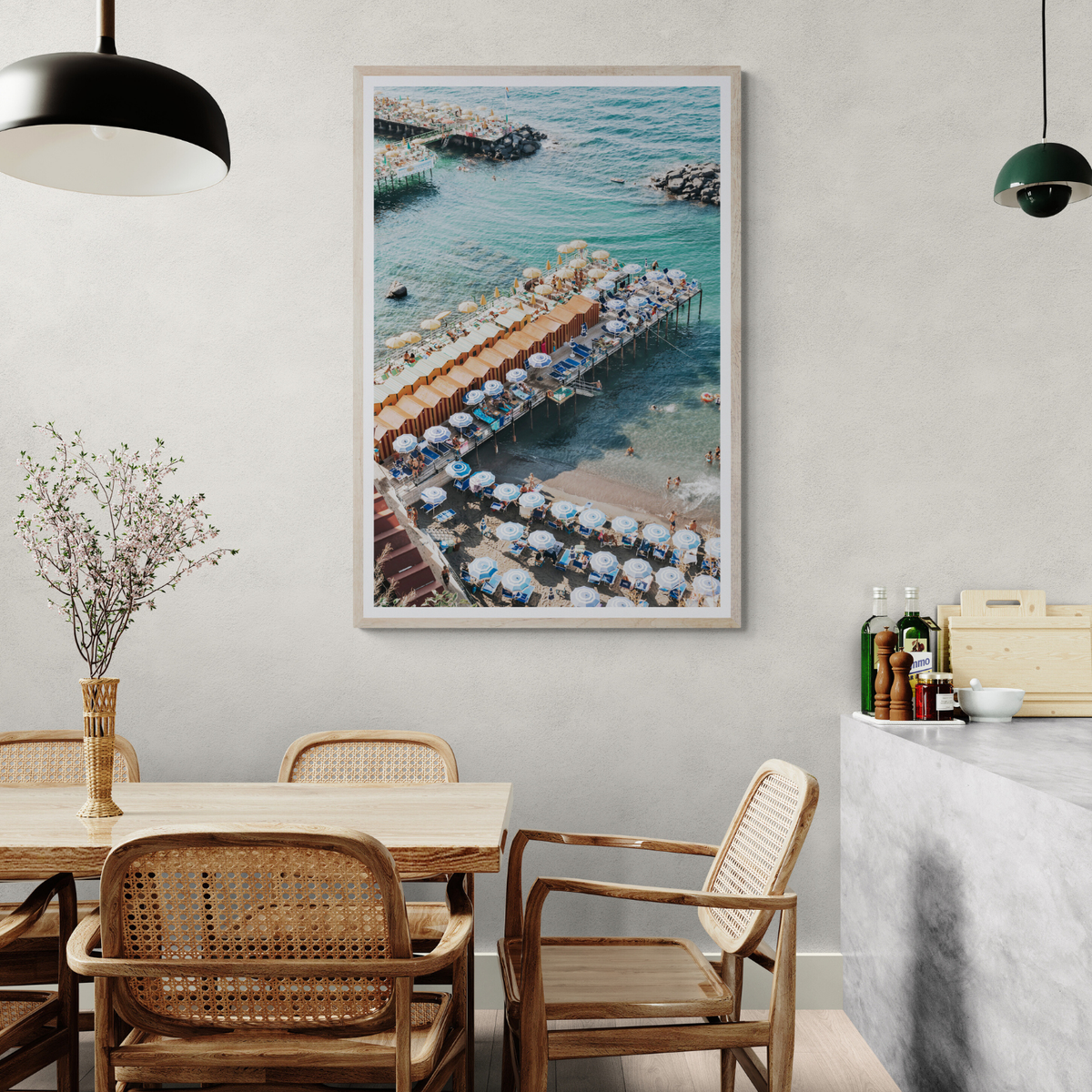 Ocean Fantasy Sorrento fine art print framed above a timber dining table with cane chairs and a black pendant light