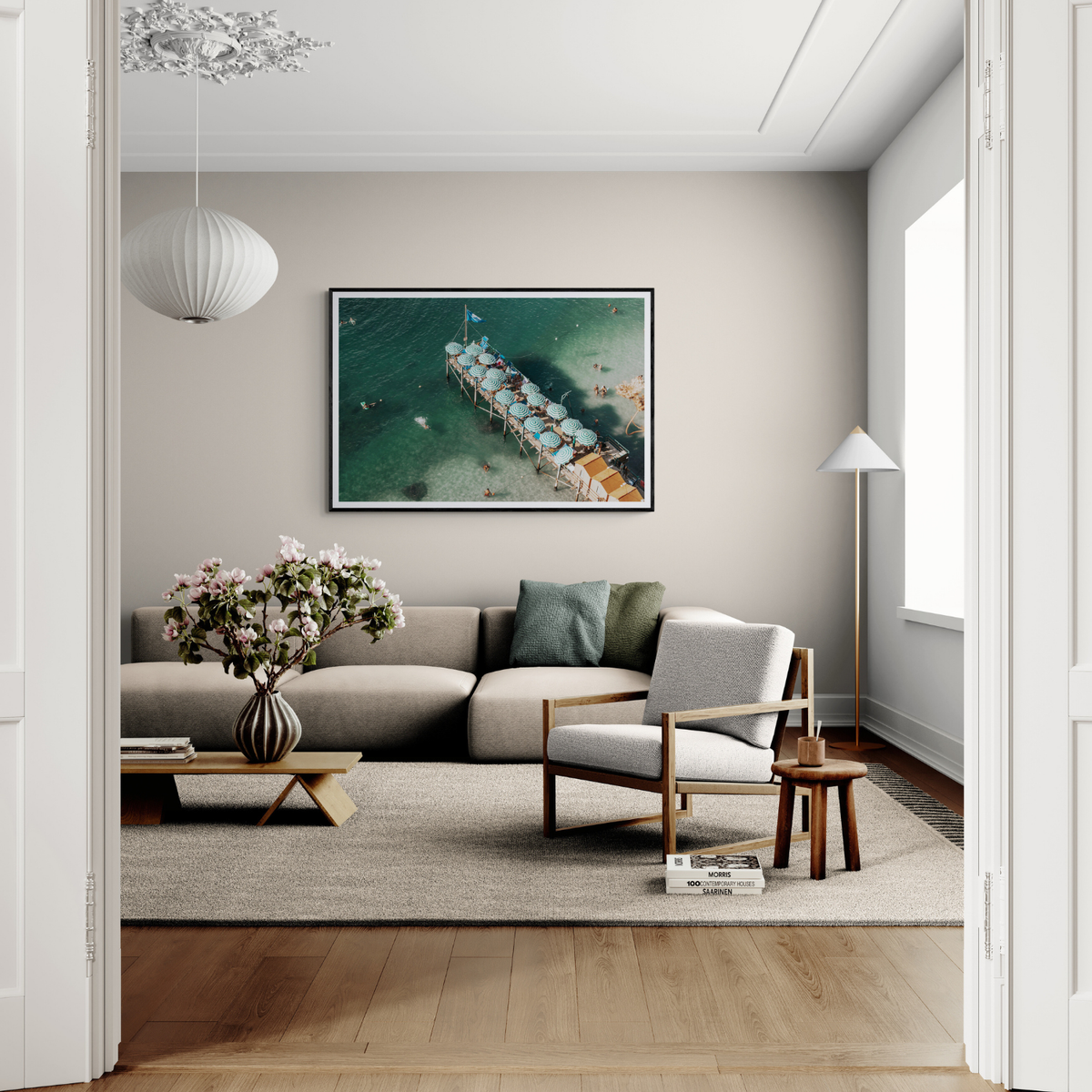 Sorrento Shangri La fine art print in a black frame above a low cream sofa in a bright living room