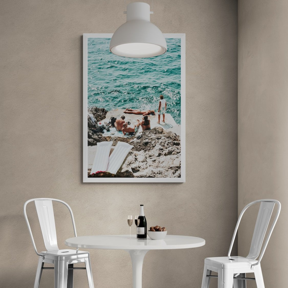 Gli Amici Praiano fine art print in a white frame above a café table with white metal chairs and a pendant light