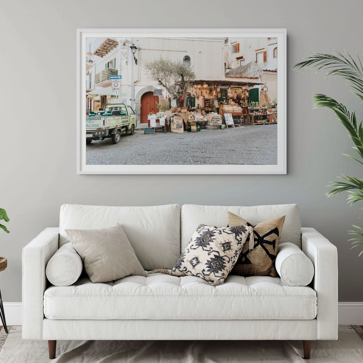 Mercatino Ischia, cobbled street market stall with olive tree and green truck, framed print styled in a room