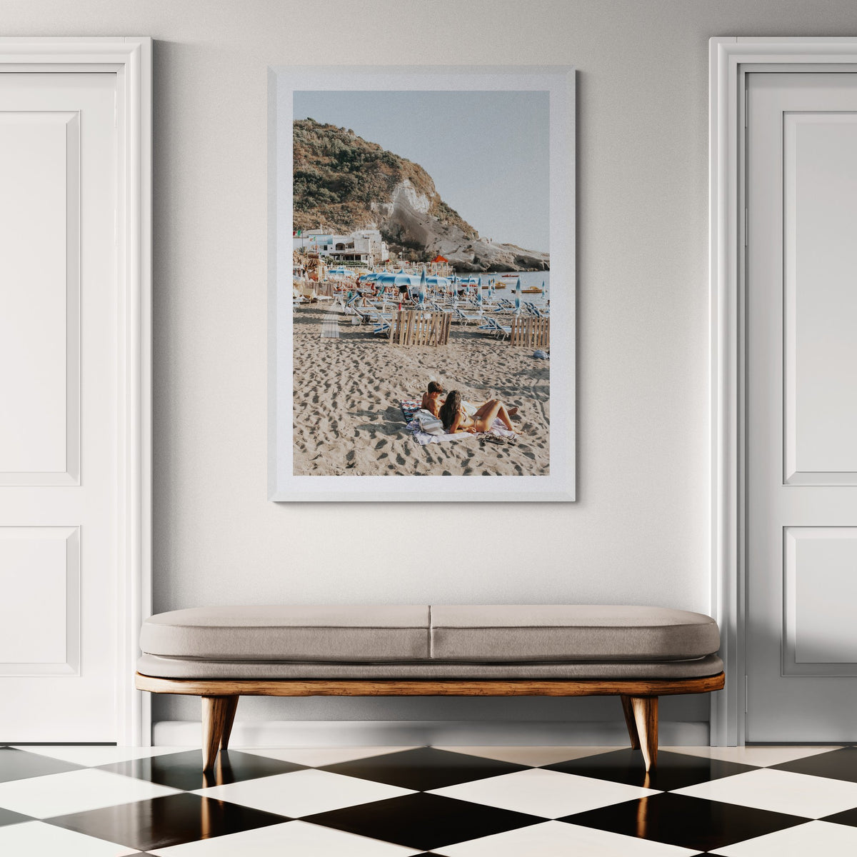 Beach Buddies Ischia fine art print framed in a classic hallway above an upholstered bench, with a checkerboard floor