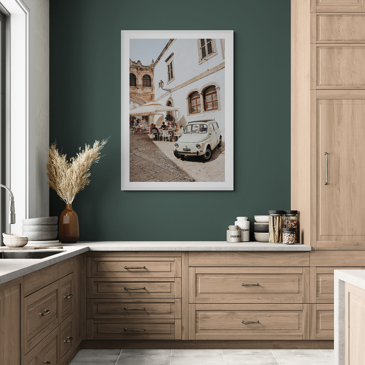 Piazza di Ostuni fine art print styled on a deep green kitchen wall above oak cabinetry