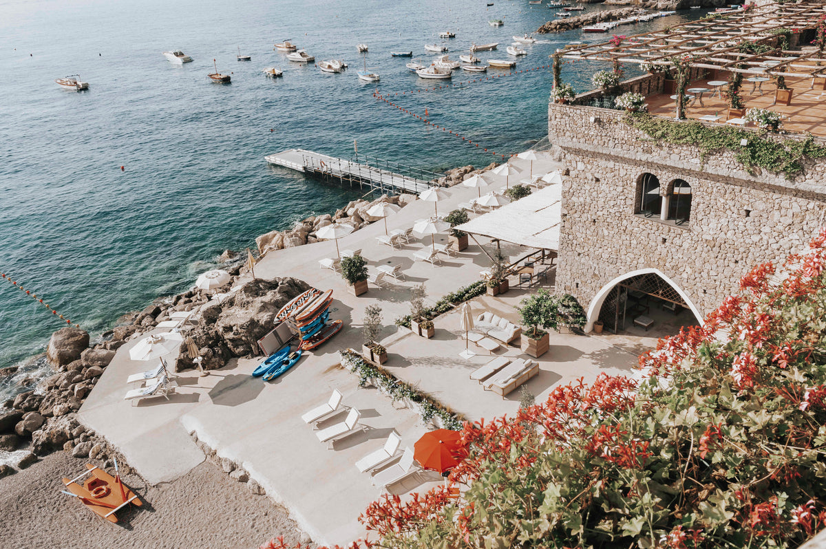 Bougainvillea spilling over a castle-like terrace above the sea in Amalfi, Italy