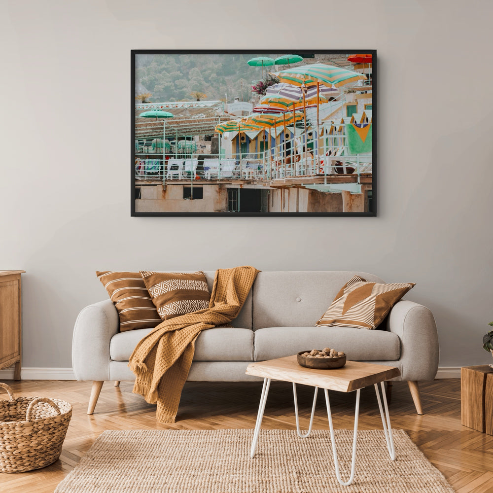 Terrace Tableau Capri, faded striped umbrellas above pastel beach huts on a terrace, framed print styled in a room view 3
