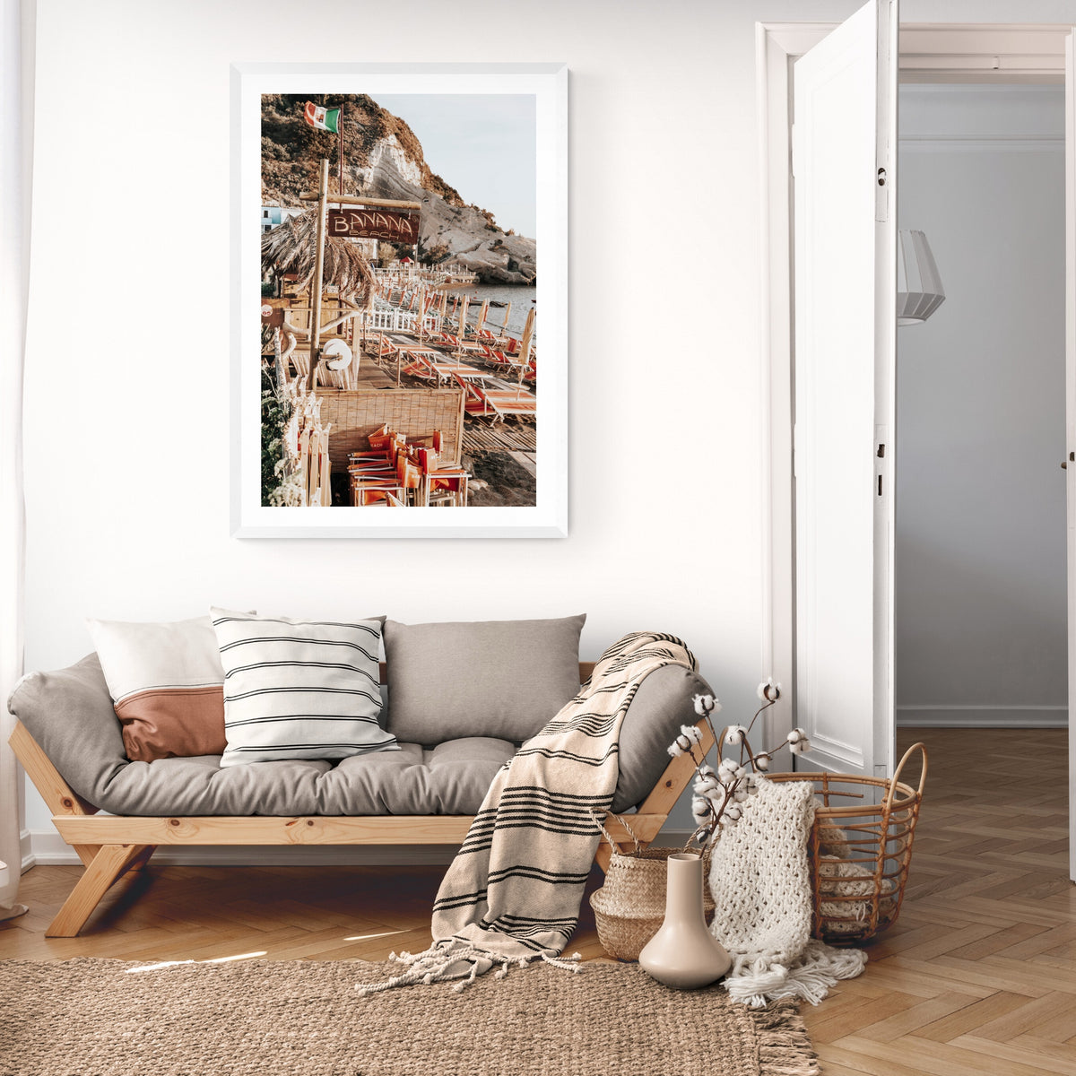 Barefoot Ischia Ischia, Banana Beach sign, striped loungers and stacked orange chairs, framed print styled in a room view 2