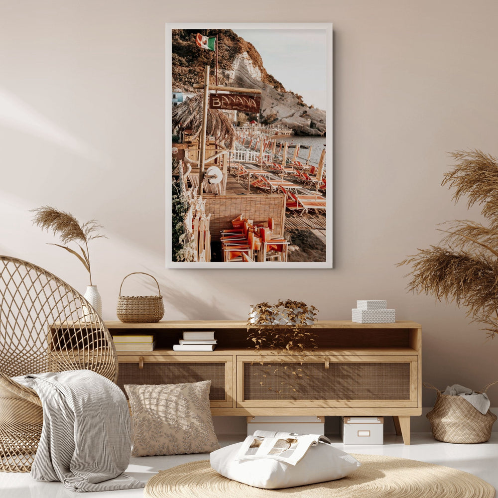 Barefoot Ischia Ischia, Banana Beach sign, striped loungers and stacked orange chairs, framed print styled in a room view 3