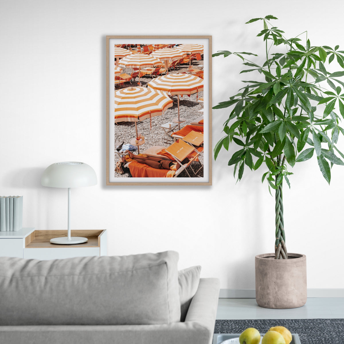 Beach Mode Positano, orange striped umbrellas, loungers and sunbather on pebbles, framed print styled in a room view 4