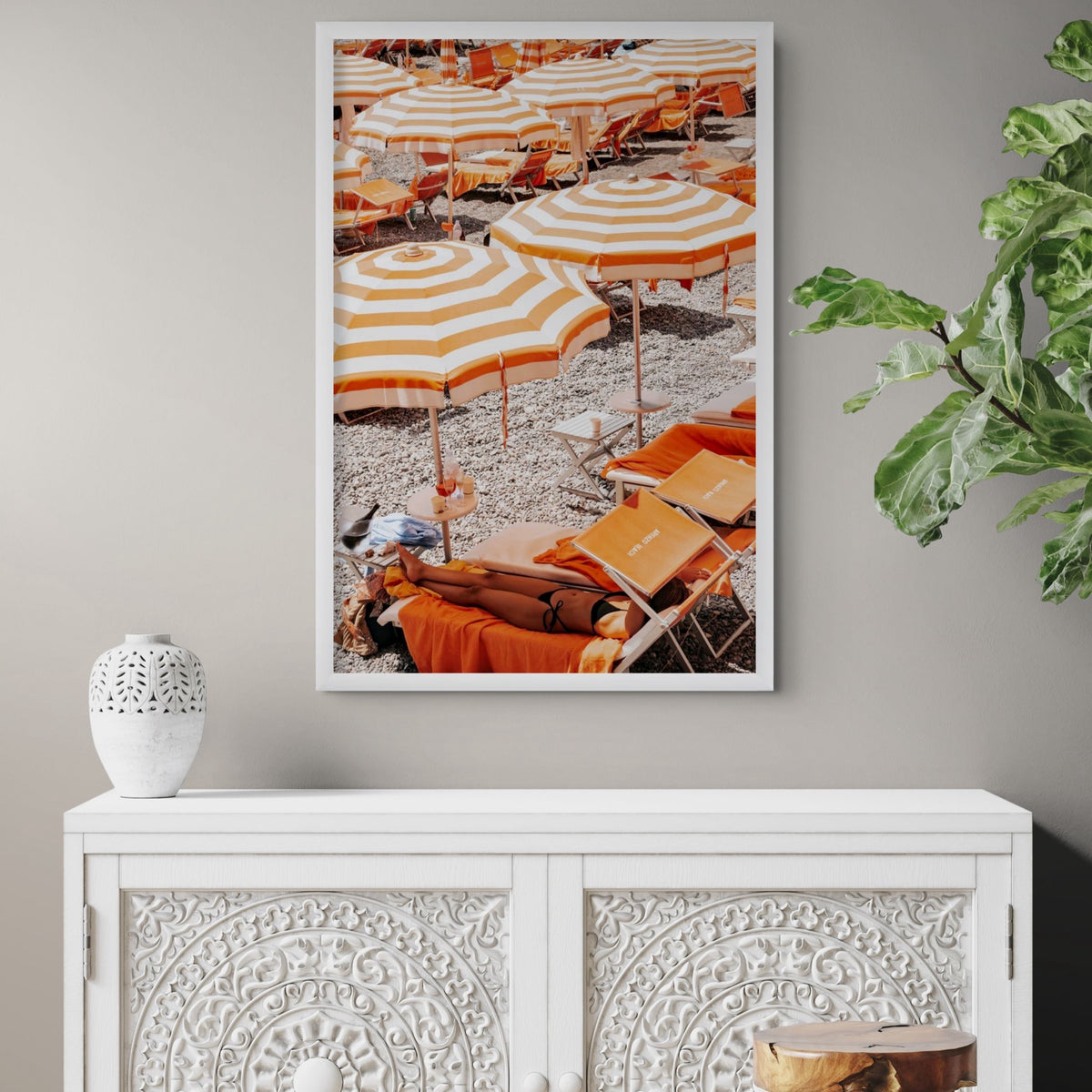 Beach Mode Positano, orange striped umbrellas, loungers and sunbather on pebbles, framed print styled in a room view 5