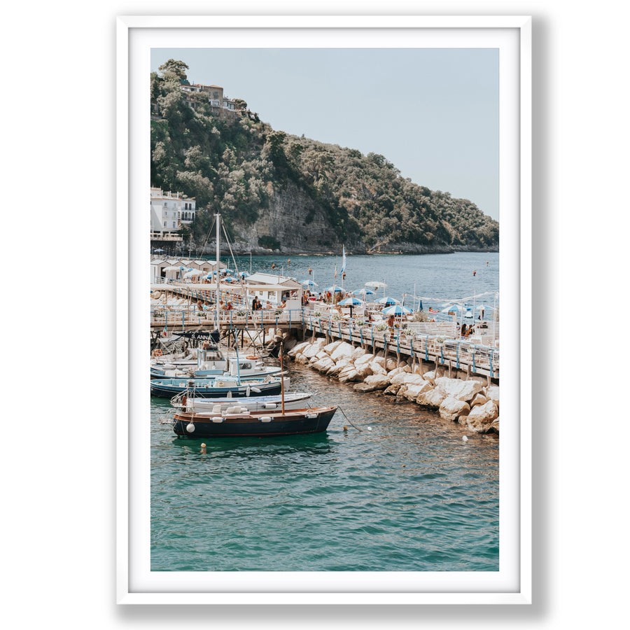 Sundeck Society Sorrento, beach club sundeck, blue umbrellas and moored boats below cliff, main fine art print image